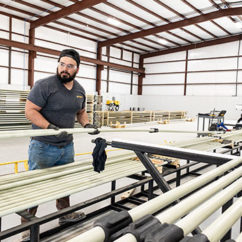 An Endurance Lift employee working with fiberglass sucker rods.